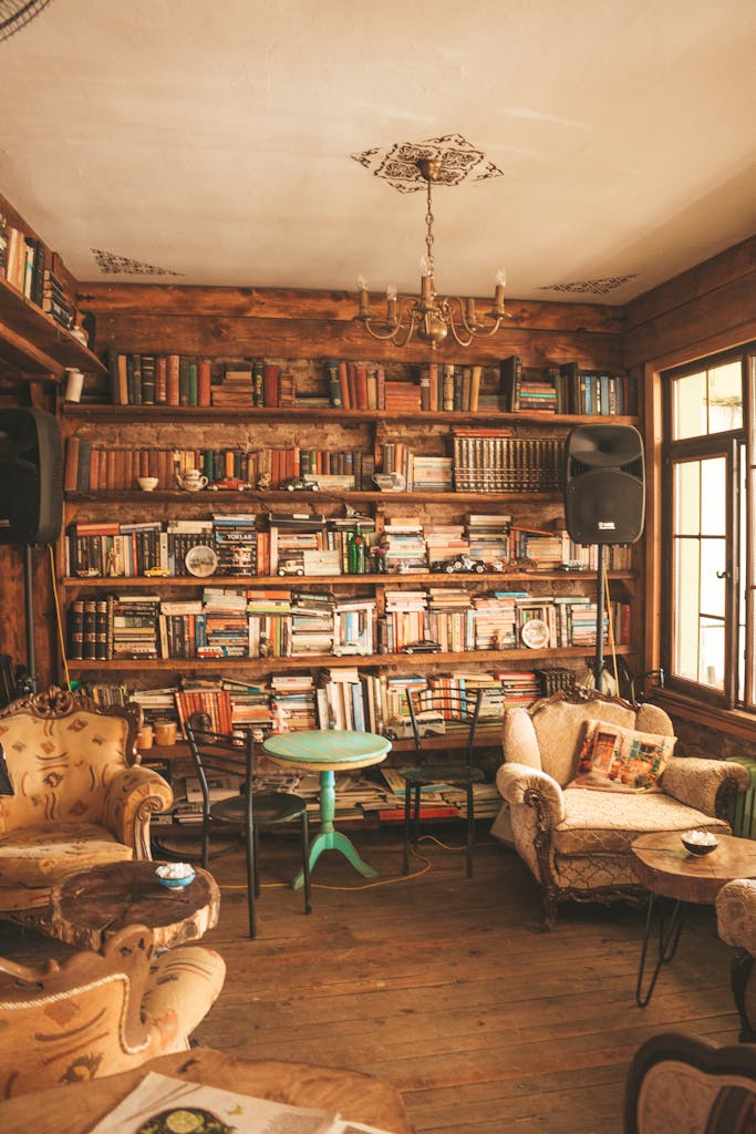 Warm and inviting library room with wooden shelves, books, and comfortable seating.