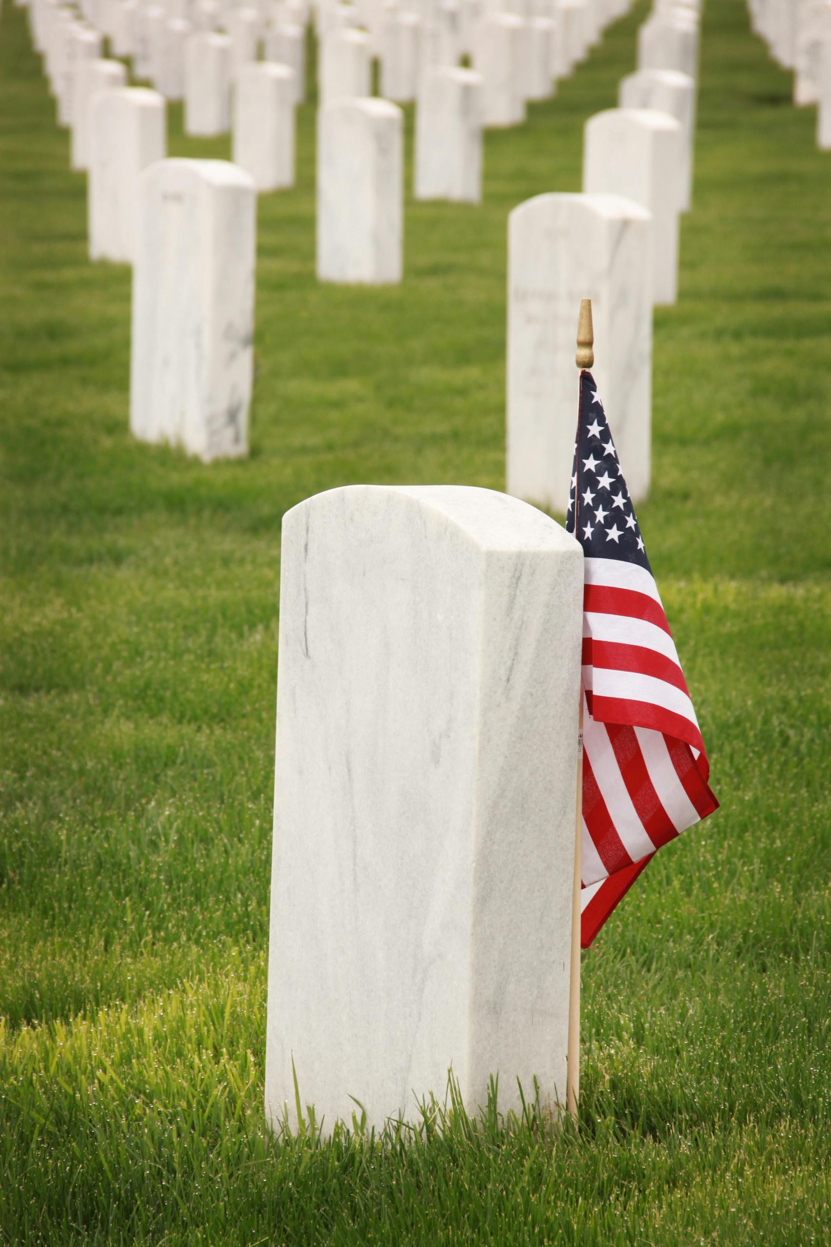 Rows of gravestones with an American flag, honoring fallen soldiers.
