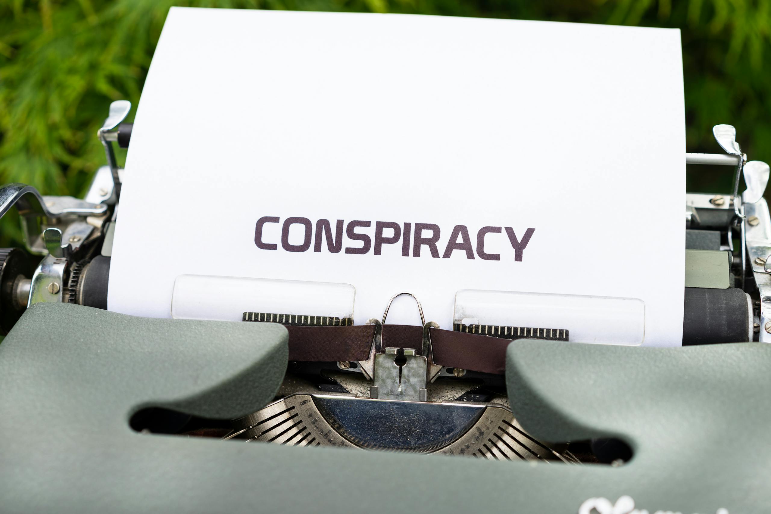 A typewriter with paper displaying the word 'CONSPIRACY.'