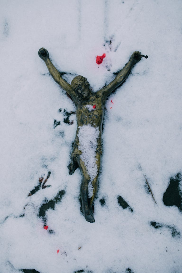 A crucifixion sculpture in snow, symbolizing religious faith and winter's purity.
