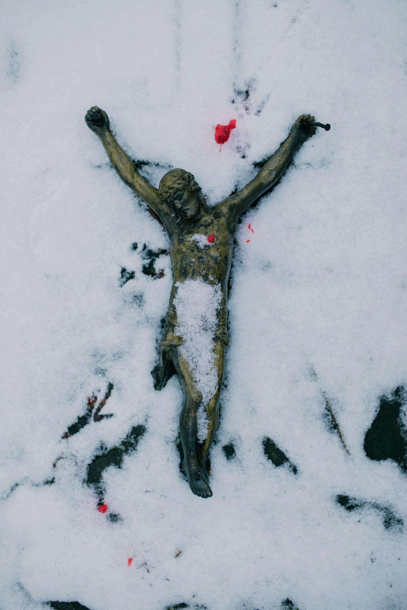 A crucifixion sculpture in snow, symbolizing religious faith and winter's purity.