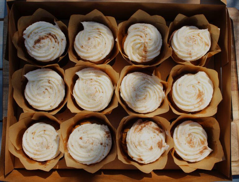 one dozen fresh milled carrot muffins with frosting