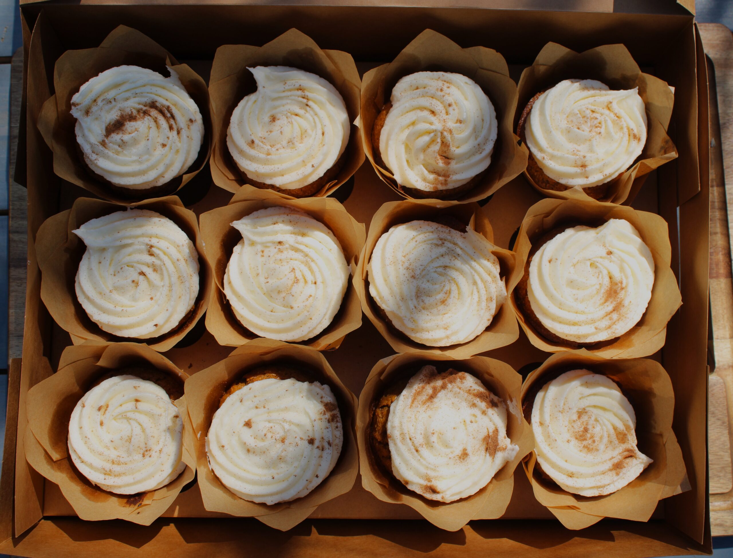 one dozen fresh milled carrot muffins with frosting