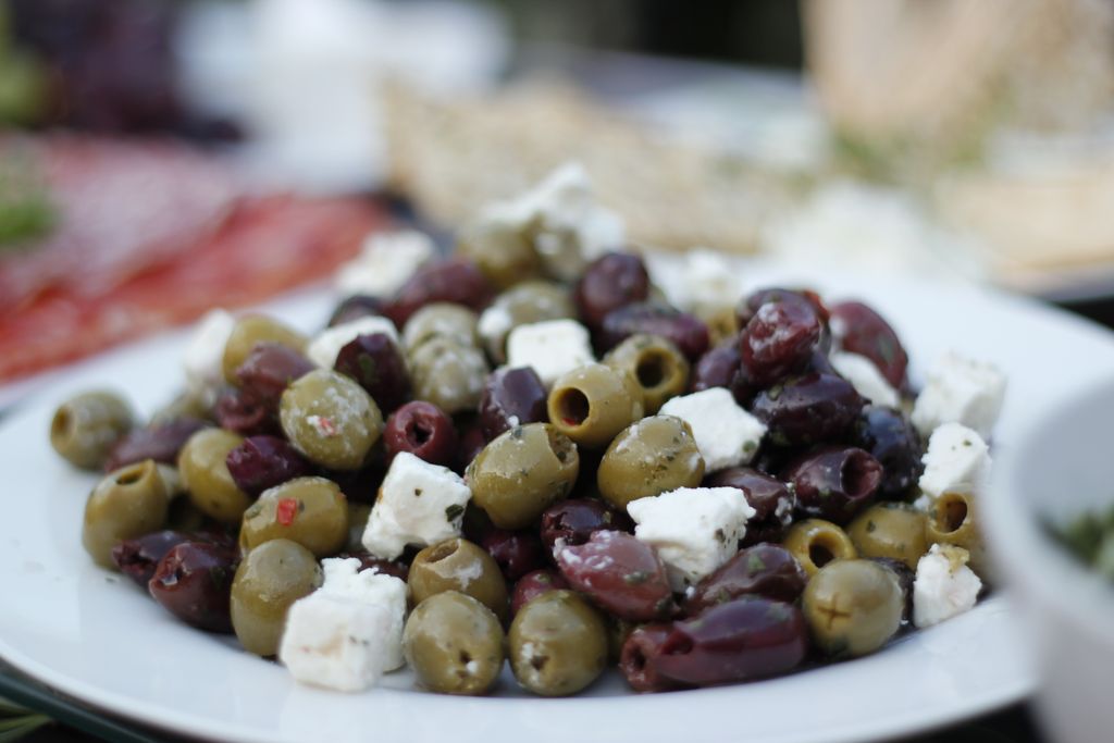 A close-up of a delicious olive and feta salad on a white plate, perfect for healthy meals.