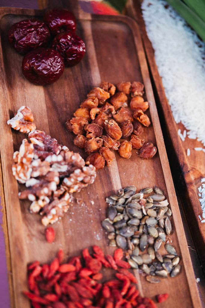 A variety of nuts and dried fruits arranged visually on a wooden tray, perfect for health-conscious snacking.