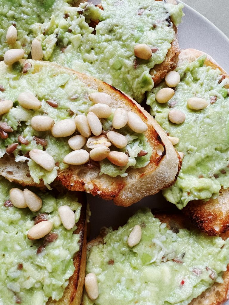 Close-up of avocado toast with pine nuts, perfect for healthy eating concepts.